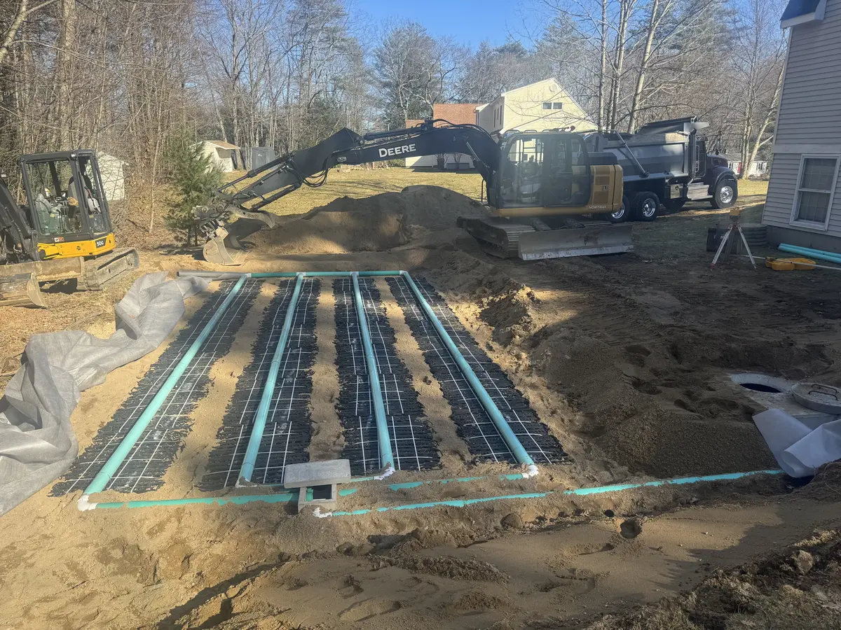 New leach field under construction with distribution pipes laid in sand